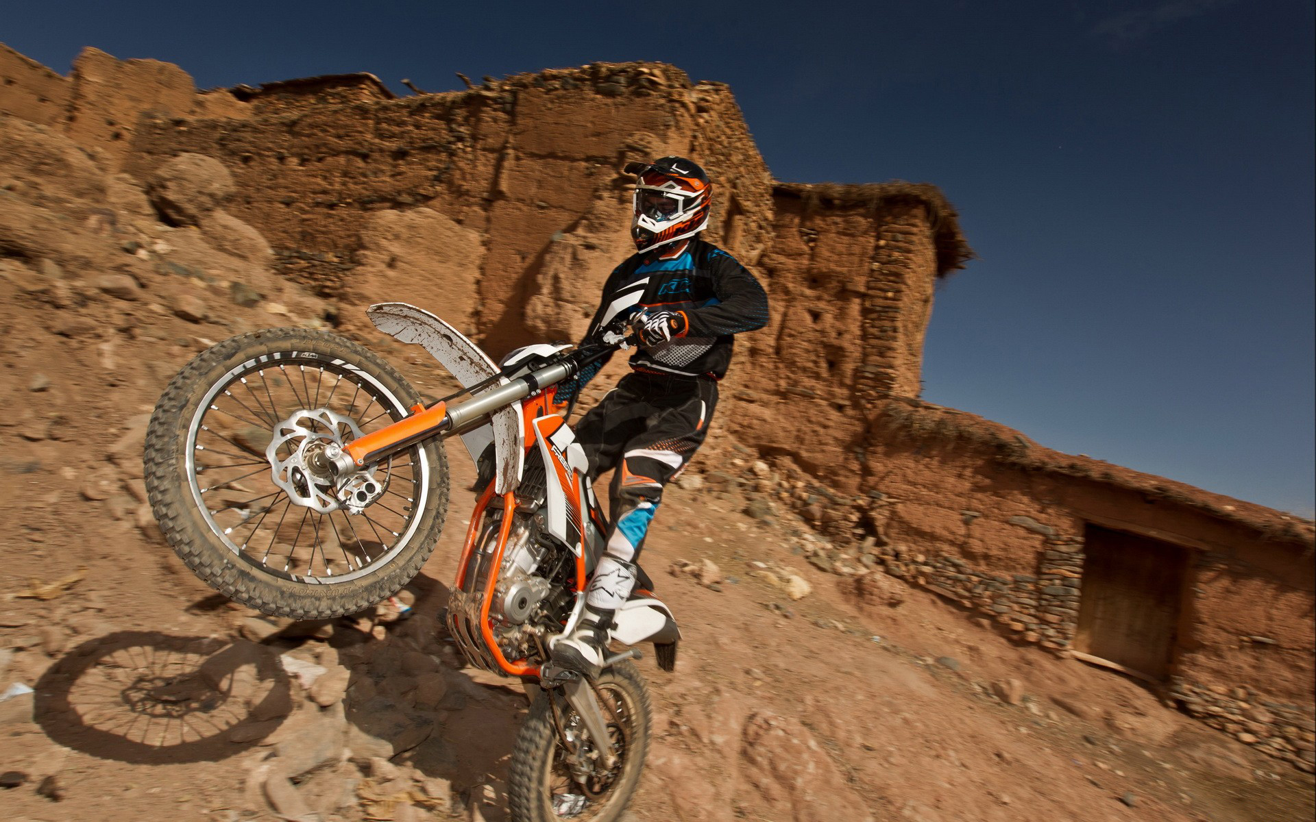 A man ridign a bike in the desert.